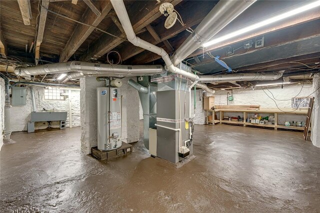 basement with heating unit, electric panel, water heater, and a sink