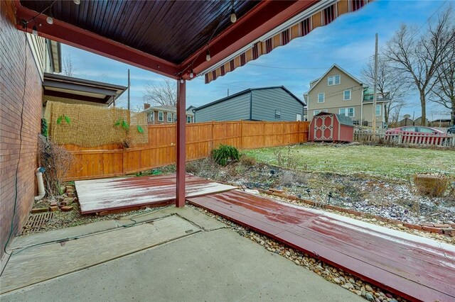 view of yard with a storage shed, a fenced backyard, and an outdoor structure