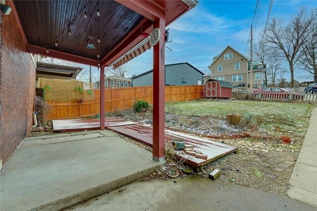 view of yard featuring a fenced backyard, a patio area, a storage unit, and an outdoor structure