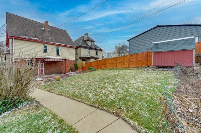 view of yard with a storage unit, an outdoor structure, and fence