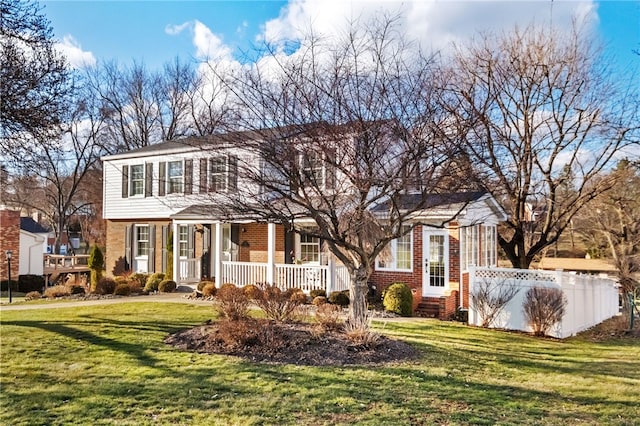 view of front of house with brick siding, a porch, and a front lawn