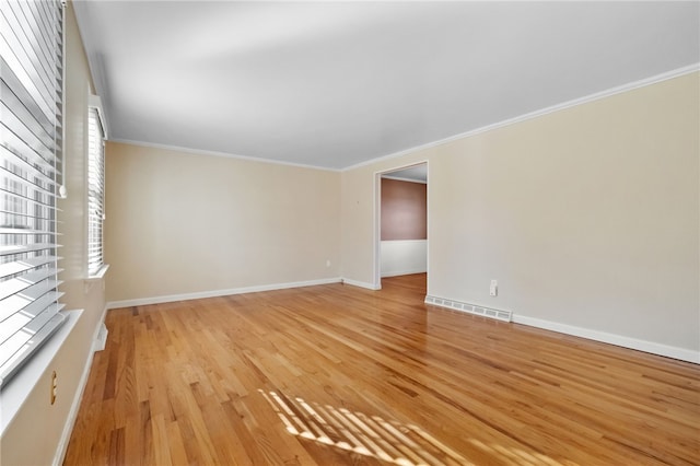 unfurnished room featuring crown molding, baseboards, visible vents, and light wood-type flooring