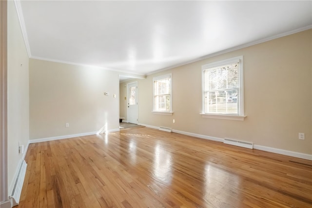 empty room with light wood-style flooring, visible vents, baseboards, and ornamental molding