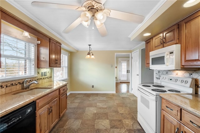 kitchen with a sink, baseboards, white appliances, and ornamental molding