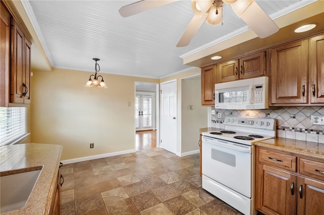 kitchen with backsplash, ornamental molding, brown cabinets, white appliances, and a sink