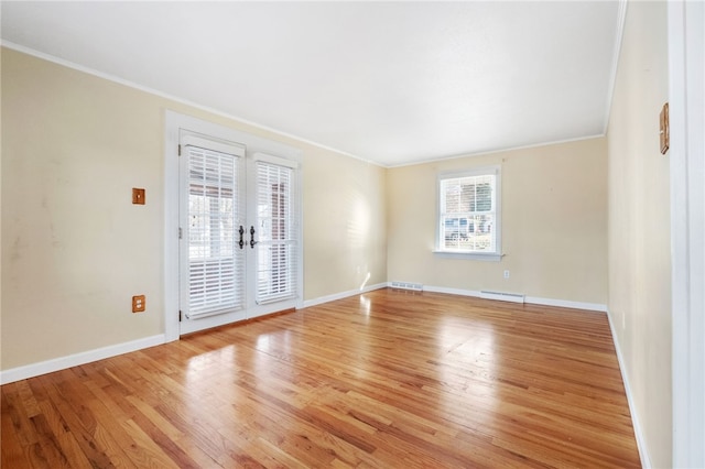 empty room with baseboards, wood finished floors, and ornamental molding