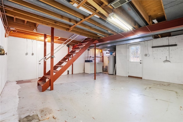 basement featuring stairway, water heater, and washing machine and clothes dryer