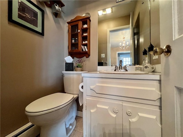 half bathroom with tile patterned flooring, baseboard heating, toilet, and vanity