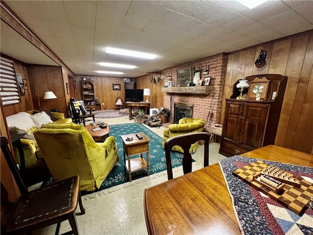 living area featuring tile patterned floors, wooden walls, and a fireplace