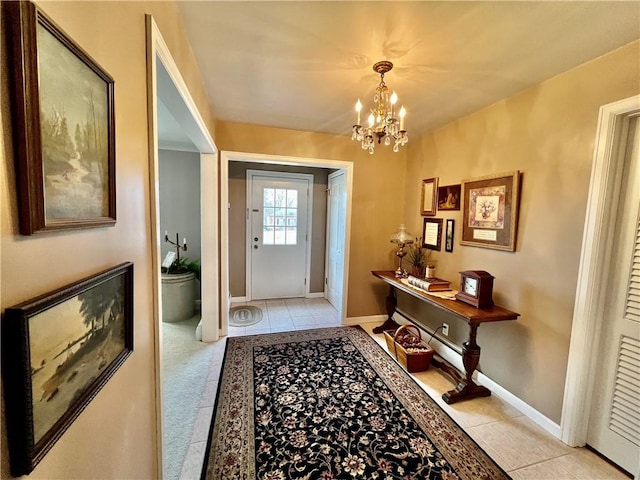 doorway with tile patterned floors, an inviting chandelier, and baseboards