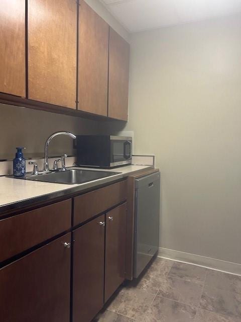 washroom with baseboards and a sink