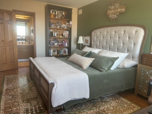 bedroom with wood finished floors and ensuite bathroom