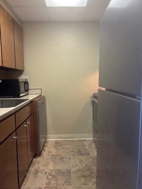 laundry room with stone finish floor and baseboards