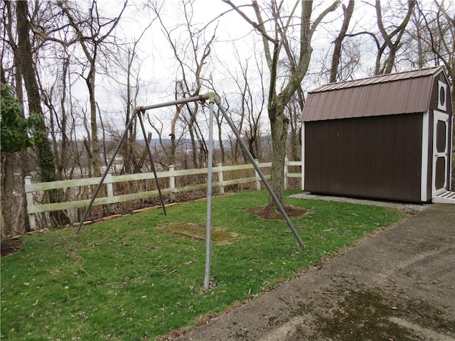 view of yard featuring an outbuilding, a shed, and fence