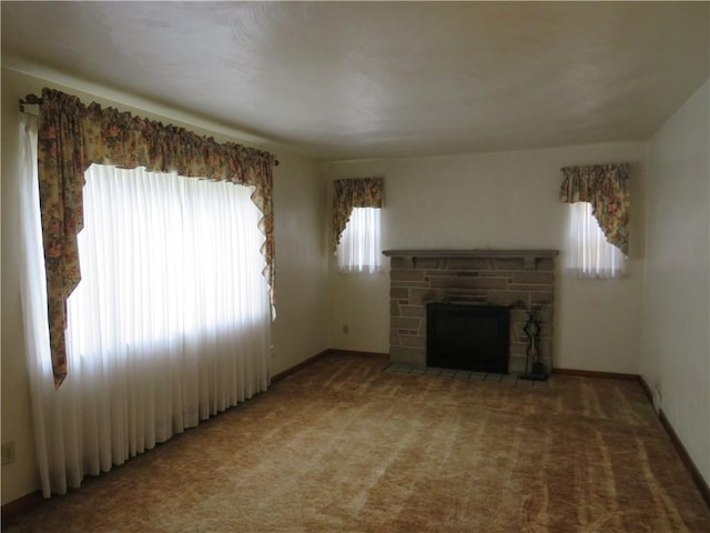 unfurnished living room with a stone fireplace, light colored carpet, and baseboards