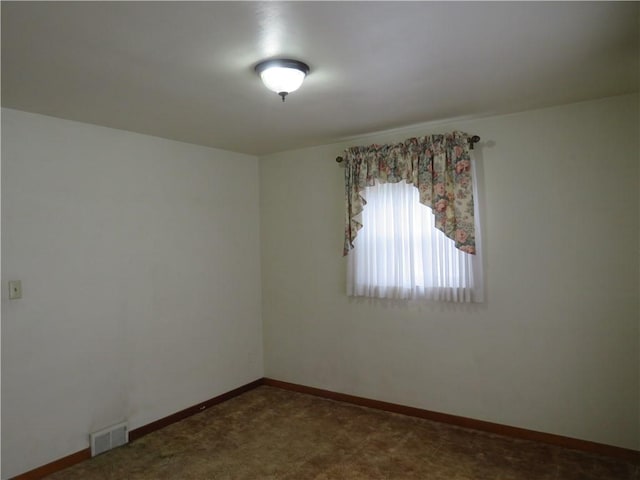 spare room featuring baseboards, visible vents, and carpet floors