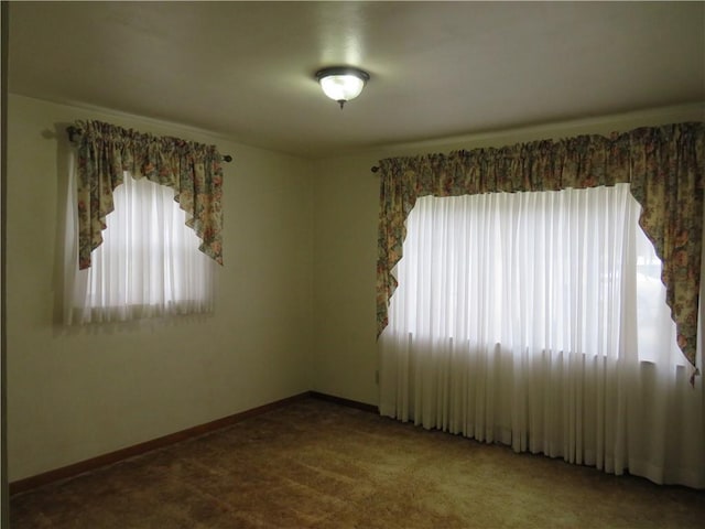 carpeted empty room with baseboards