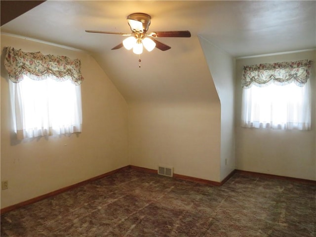 additional living space featuring a ceiling fan, baseboards, visible vents, carpet floors, and lofted ceiling