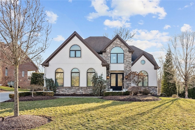 french country inspired facade with stone siding, stucco siding, and a front lawn