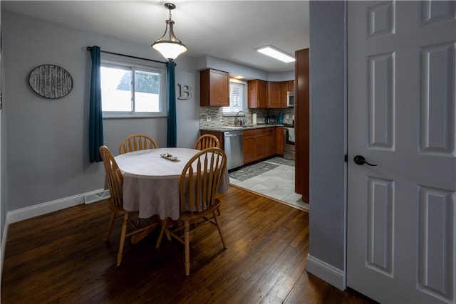 dining area featuring visible vents, baseboards, and wood finished floors