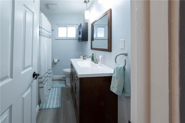 bathroom featuring vanity, a shower with shower curtain, wood finished floors, baseboards, and toilet