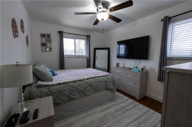 bedroom featuring baseboards, a ceiling fan, and wood finished floors