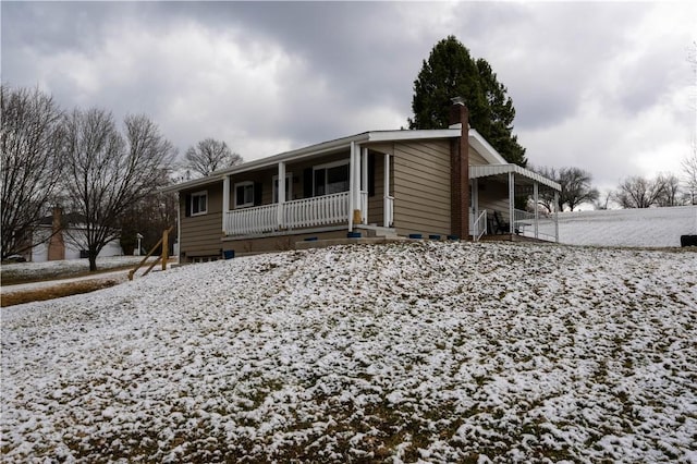 view of front of home featuring crawl space, covered porch, and a chimney