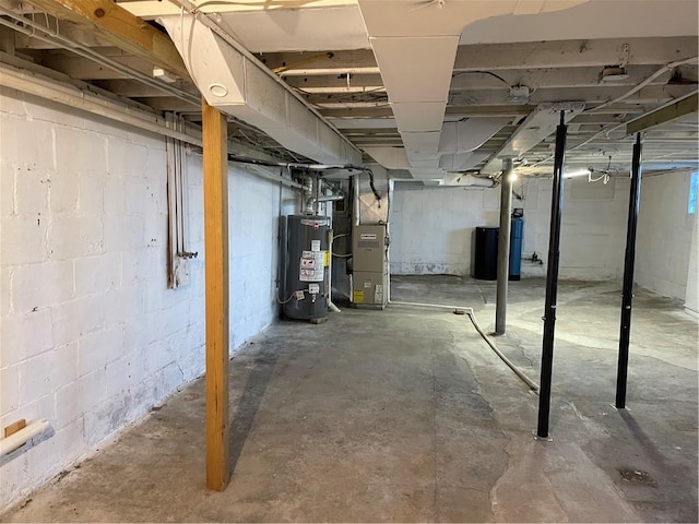 unfinished below grade area featuring heating unit and gas water heater