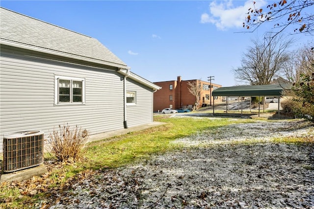 view of yard with a detached carport and central AC