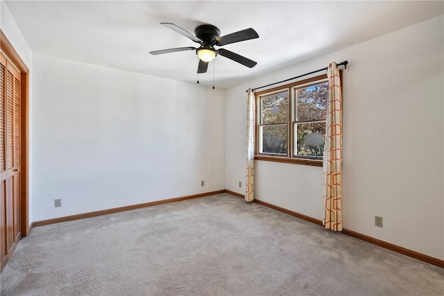 empty room featuring a ceiling fan, carpet, and baseboards