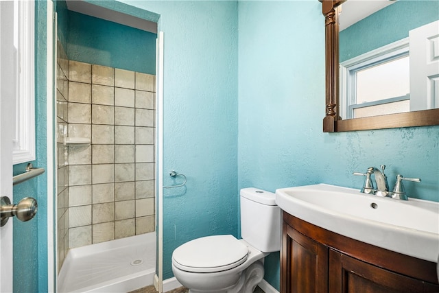 full bathroom with a shower stall, toilet, vanity, and a textured wall