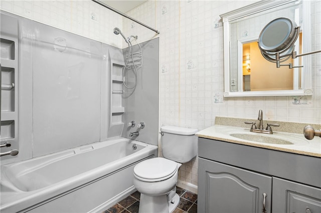 bathroom with toilet, vanity, tile walls, and shower / bathing tub combination