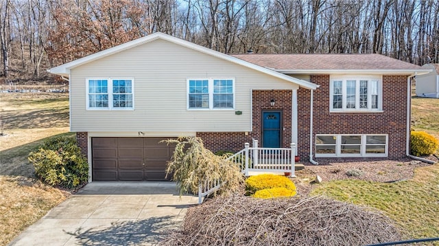 bi-level home with brick siding, concrete driveway, and an attached garage