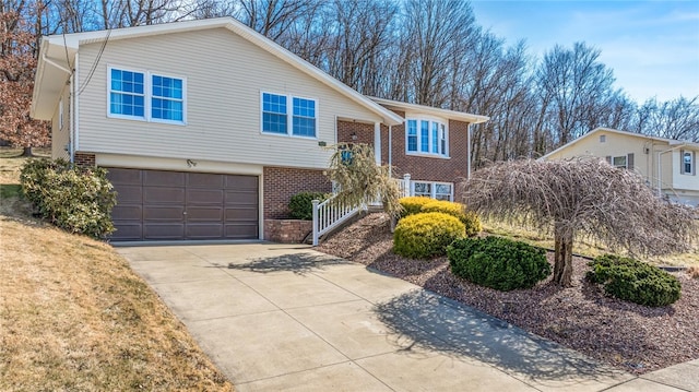 split foyer home with a garage, brick siding, and driveway