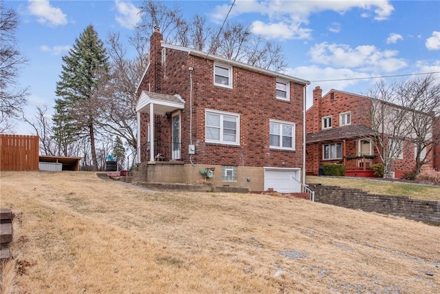 view of front of property with an attached garage, fence, brick siding, and a chimney