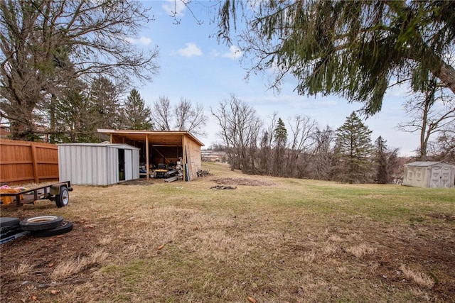 view of yard with a pole building, a storage shed, an outdoor structure, and fence