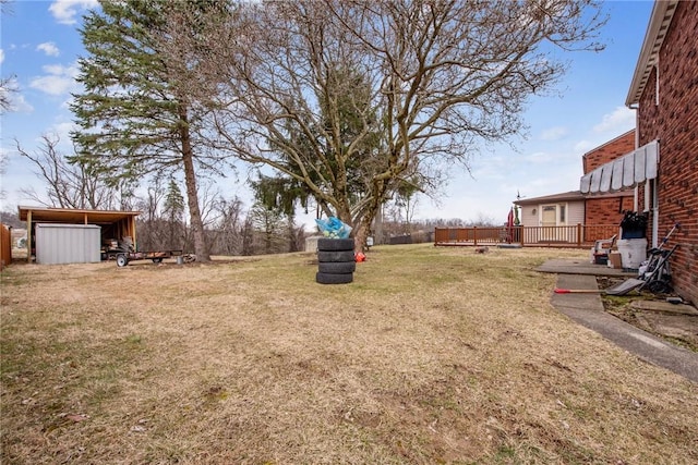 view of yard featuring a deck and an outbuilding