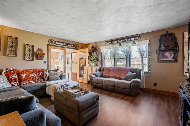 living area featuring wood finished floors, baseboards, and a textured ceiling