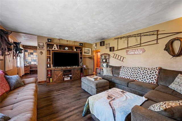 living room with a textured ceiling, baseboards, and wood finished floors