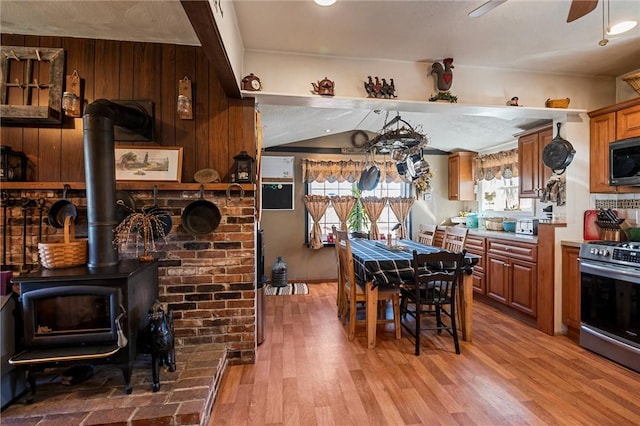 kitchen featuring ceiling fan, brown cabinetry, light wood-type flooring, and stainless steel appliances