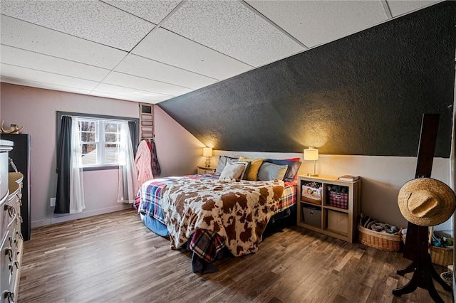 bedroom with wood finished floors and vaulted ceiling