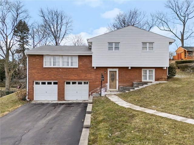 tri-level home featuring aphalt driveway, a garage, brick siding, and a front lawn