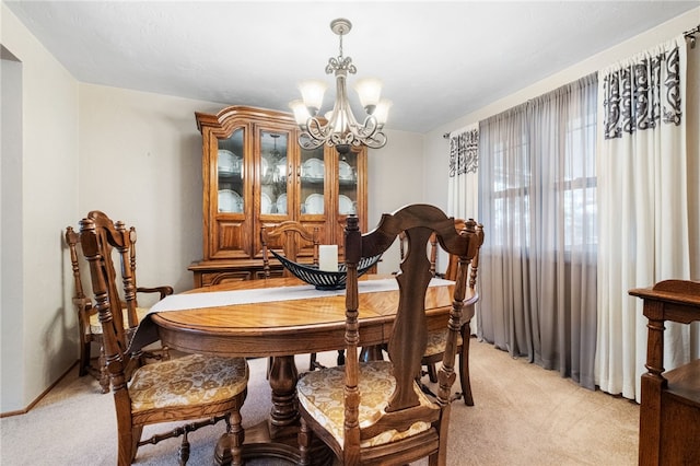 dining area featuring an inviting chandelier and light colored carpet