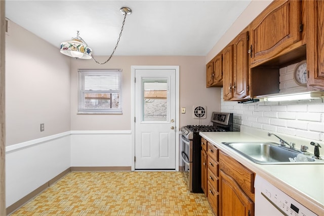 kitchen featuring brown cabinets, a sink, light countertops, range with two ovens, and dishwasher