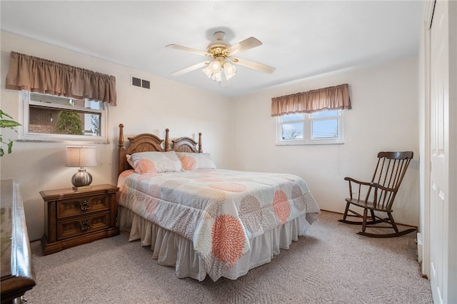 bedroom featuring light colored carpet, visible vents, and ceiling fan