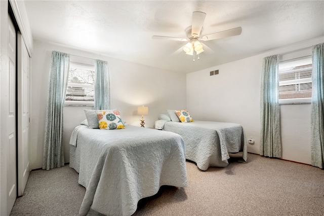 bedroom featuring visible vents, a closet, ceiling fan, and carpet flooring