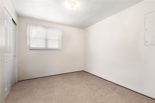 unfurnished bedroom featuring electric panel, a closet, and carpet floors