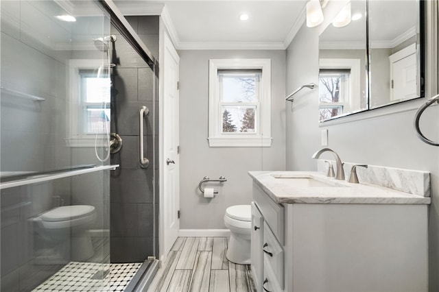 bathroom featuring a stall shower, toilet, and crown molding