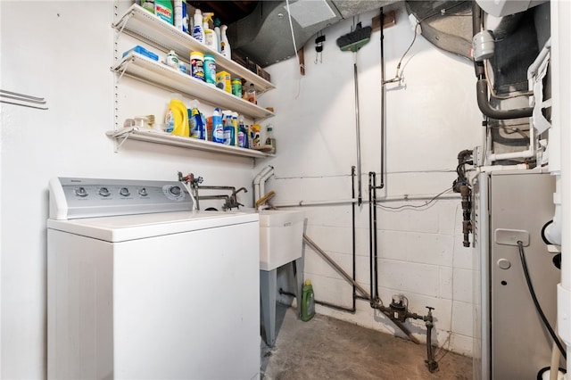 clothes washing area with laundry area, concrete block wall, and washer / clothes dryer