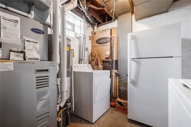 washroom featuring heating unit, laundry area, and washing machine and dryer